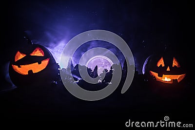 Halloween concept with glowing pumpkins. Strange silhouette in a dark spooky forest at night, mystical landscape surreal lights Stock Photo