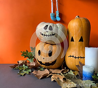 Halloween concept with jack o lantern pumpkins, autumn leaves, candles and character legs Stock Photo