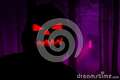 Halloween creepy hooded silhouette with a evil pumpkin face standing in a horror forest with a haunted house in the background Stock Photo