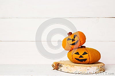 Halloween cute orange handmade felt pumpkins on an old white wooden background with copy space. Halloween kids craft background. Stock Photo