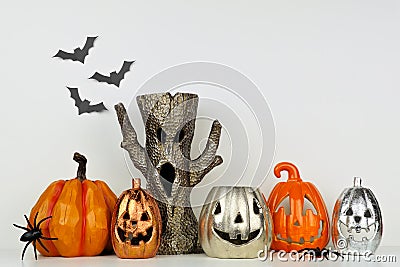 Halloween decor with jack o lantern and spooky tree against a white wall Stock Photo