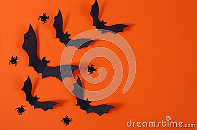 Halloween decor with spiders and black paper bats flying over orange background Stock Photo