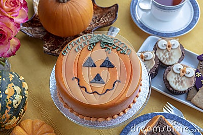 Halloween decorated cake and gingerbread served on ceramic plate. Stock Photo