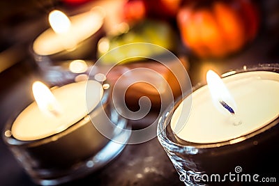 Halloween Decoration With Three Candlelights, Chocolate And Pumpkins On Slate Stock Photo