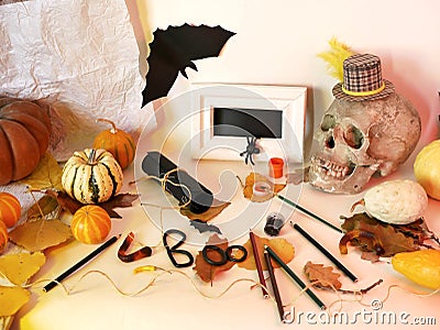 Halloween decorative still life with pumpkins, skull, white frame, bats, art materials and holiday decorations Stock Photo