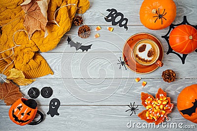 Halloween holiday background with coffee cup, pumpkin and autumn leaves on wooden table. Top view from above. Flat lay Stock Photo
