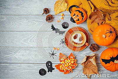 Halloween holiday background with coffee cup, pumpkin and autumn leaves on wooden table. Top view from above. Flat lay Stock Photo