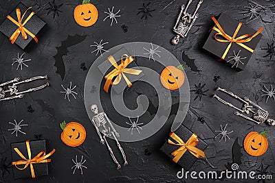 Halloween holiday background with gifts and decorations on black backdrop Stock Photo