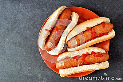 Halloween hot dog fingers on an orange plate over slate Stock Photo