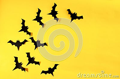 Flying black paper bats isolated on yellow background Stock Photo