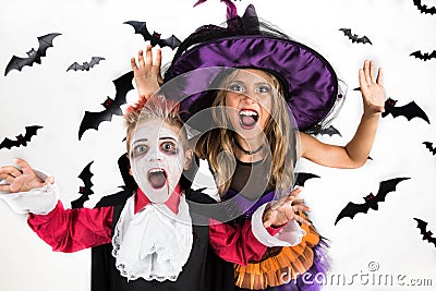 Halloween kids, Happy scary girl and boy dressed up in halloween costumes of witch, sorcerer and vampire Dracula for pumpkin patch Stock Photo