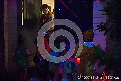 Halloween and kids trick or treating going door to door at night Editorial Stock Photo