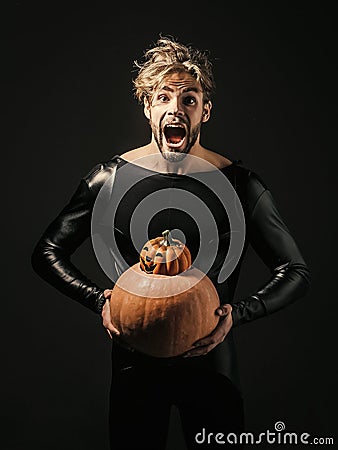 Halloween macho holding two pumpkins on dark background Stock Photo