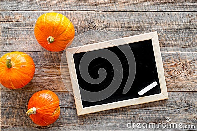 Halloween mockup. Chalkboard near pumpkins on wooden background top view Stock Photo