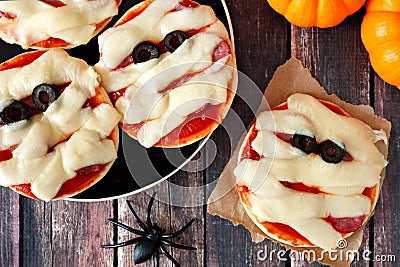 Halloween mummy mini pizzas overhead scene on rustic wood Stock Photo