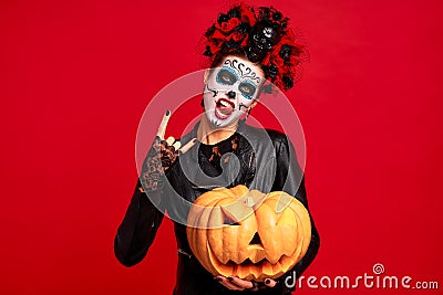 Halloween Party girl. Happy girl with sugar skull makeup, with a wreath of flowers on her head and skull, wearth lace gloves and Stock Photo
