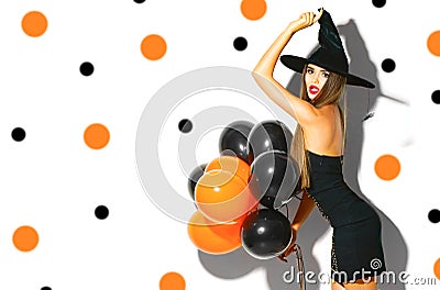 Halloween party girl. witch holding black and orange air balloons Stock Photo