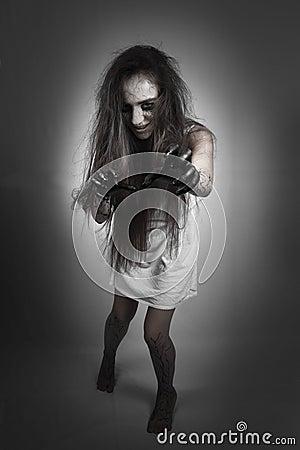 Halloween. possessed by spirits, a zombie girl walks and stretches with black hands. concept of halloween and day of the dead. Stock Photo