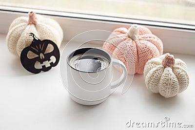 Halloween preparation. Craft halloween decorative handmade pumpkins and up of hot coffee americano on the window sill. Stock Photo