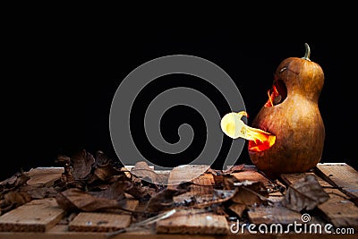 Halloween pumpkin minion spewing flames of fire on a black background Stock Photo