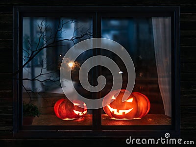 Halloween pumpkin in the mystical house window at night Stock Photo