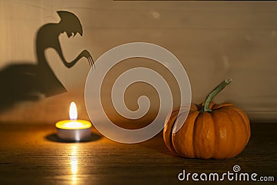 Halloween pumpkin on old wooden background. Spirit monster behind. Shadow theatre concept Stock Photo