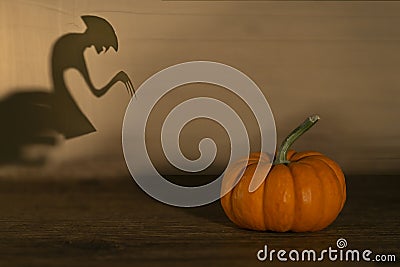Halloween pumpkin on old wooden background. Spirit monster behind. Shadow theatre concept Stock Photo