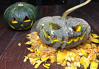 Halloween is the pumpkin. Halloween pumpkins decorated with pumpkin seeds placed on a wooden table. Stock Photo
