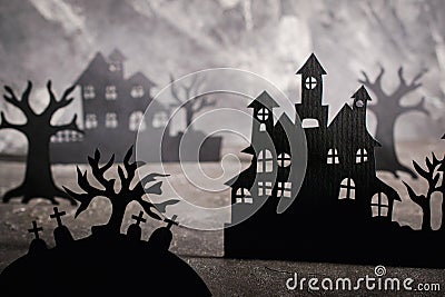 Halloween scene. Paper houses and dark misty trees in graveyard Stock Photo