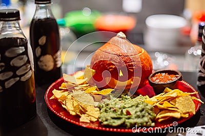 Halloween snack party plate with carved pumpkin, nachos, guacamole and salsa dip Stock Photo