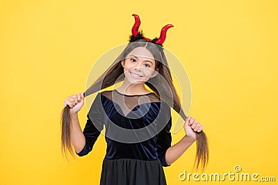 Halloween teen girl in red imp horns hold hair and playing trick o treat, happy halloween fun Stock Photo