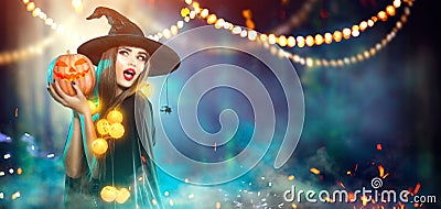 Halloween. Witch with a carved pumpkin and magic lights Stock Photo