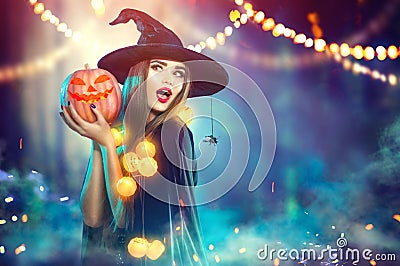 Halloween. Witch with a carved pumpkin and magic lights Stock Photo