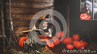 Halloween. witch child conjures with book of spells, magic wand and pumpkins Stock Photo