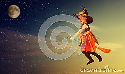 Halloween. Witch child flying on broomstick at sunset night sky. Stock Photo