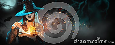 Halloween Witch girl with magic Book of spells portrait. Beautiful young woman in witches hat conjuring, making witchcraft Stock Photo