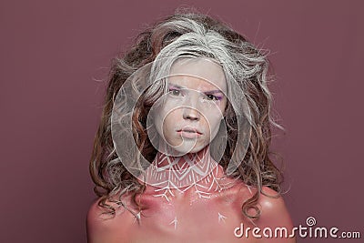 Halloween witch woman portrait. Beautiful young woman with creative makeup and long curly hair on pink background Stock Photo