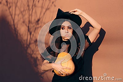 Halloween Woman in Witch Costume Holding Pumpkin Stock Photo