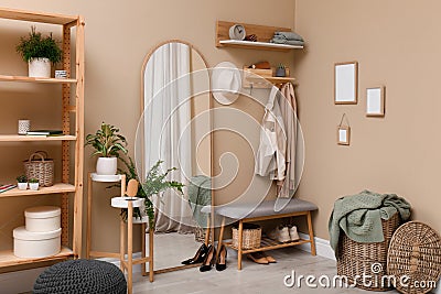 Hallway interior with stylish furniture, accessories and wooden hanger for keys on beige wall Stock Photo