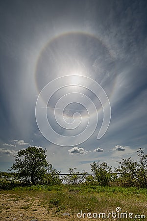 Halo around the sun in a layer of cirrostratus clouds. Stock Photo