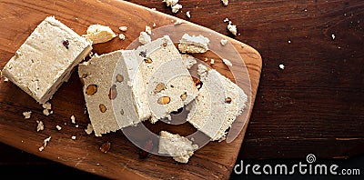 Halva almond nuts slices on wooden table background, top view Stock Photo