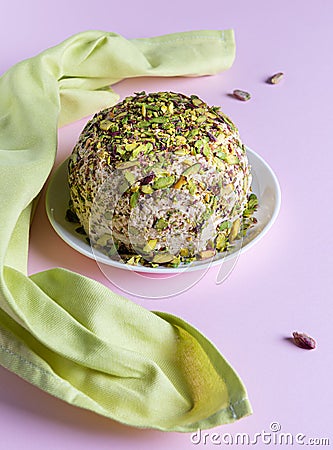 Halva with chopped pistachios and green napkin on pink background Stock Photo