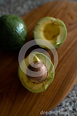 Halved avocados - Top view of fresh fruit getting cut on a board Stock Photo