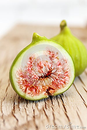 Halved, ripe figs close up on raw, grainy wood Stock Photo