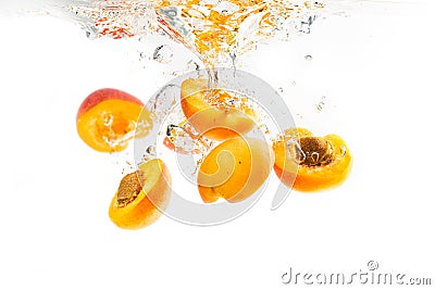 Halves of apricots dropped into water an sinking Stock Photo