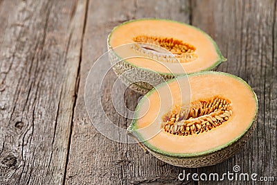 Halves of cantaloupe melon on old wooden planks Stock Photo