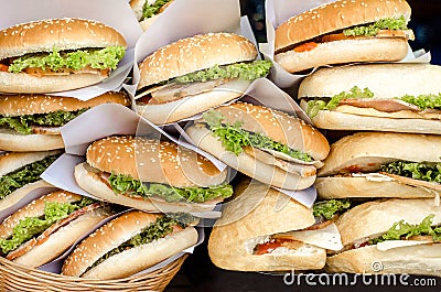 Ham and cheese burgers with greem salad ketchup and sauce lying on a shop window. Stock Photo