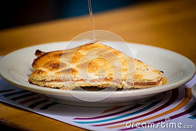 ham and cheese sandwich baked on a plate on a wooden table Stock Photo