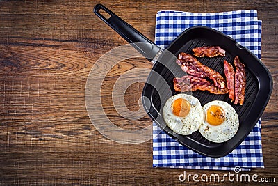 Ham and Egg. Bacon and Egg. Salted egg and sprinkled with black pepper. Grilled bacon, two eggs in a Teflon pan Stock Photo