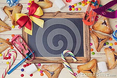 Hamantaschen cookies and chalkboard on wooden white table. View from above Stock Photo